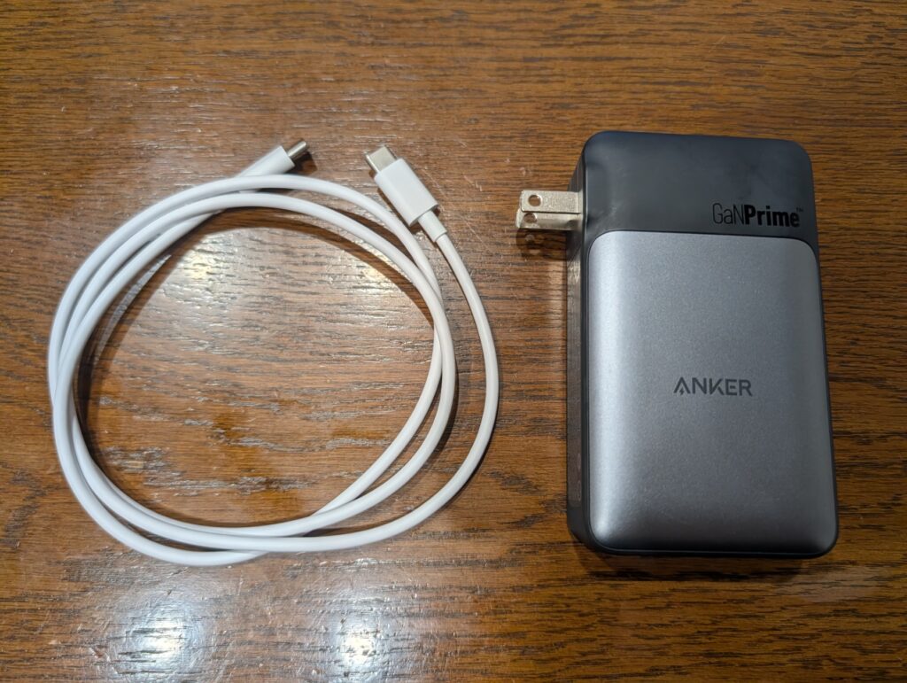 リビングの木目テーブルの上に置いたAnker 733 Power Bank本体と持ち運び用ケーブル